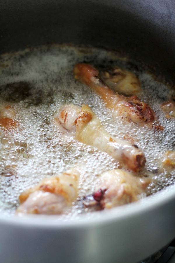 Chicken frying in a pan.