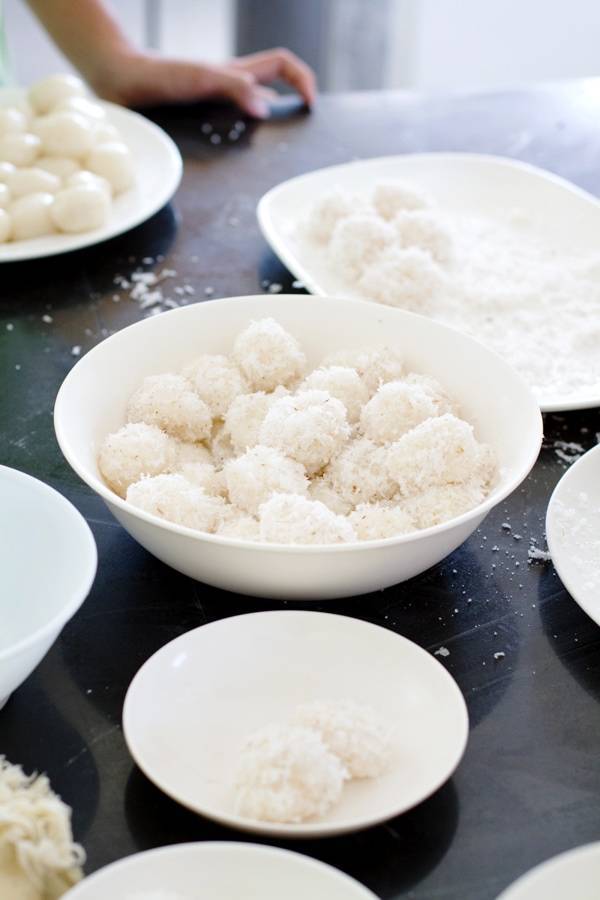 Coconut and sugar coated Filipino palitaw in white bowls.