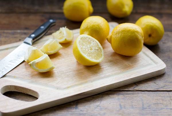 Cut lemons on a wooden cutting board.