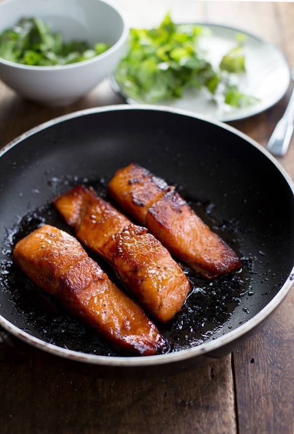 Caramelized salmon in a skillet.