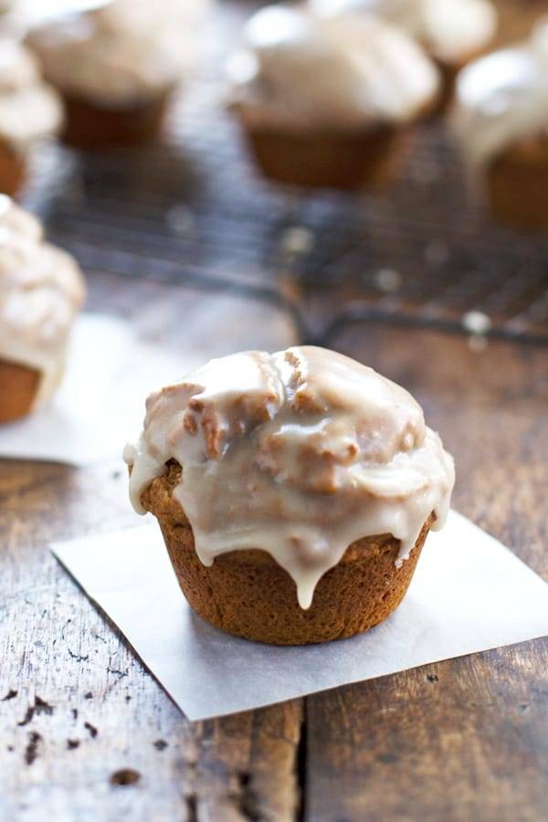 Healthy Maple Glazed Pumpkin Muffins on a piece of parchment paper.