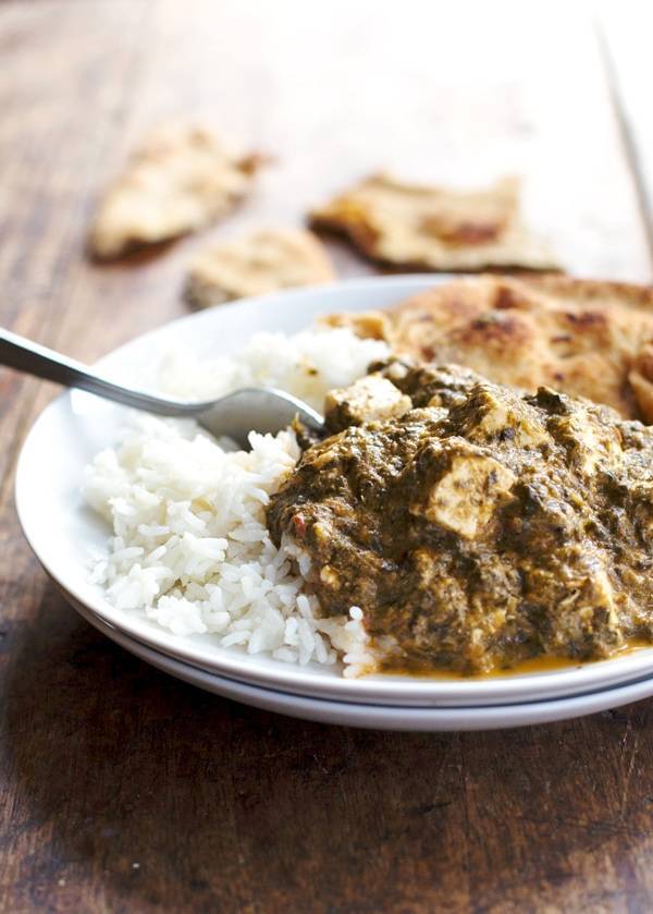 Palak paneer with rice on a plate.