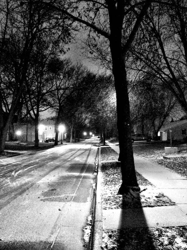 Road and sidewalk at night.