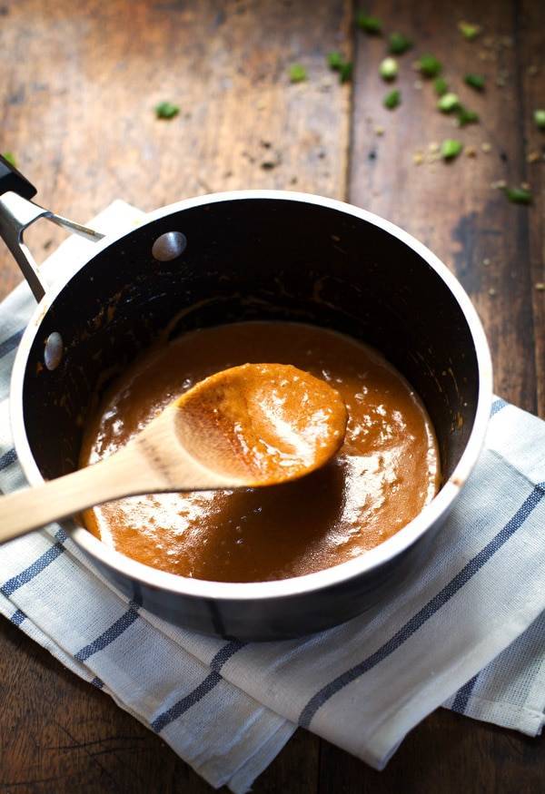 Thai Curry Sauce in a pan with a wooden spoon.