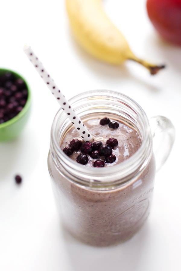 Honey and Wild Blueberry Smoothie with blueberries and a straw.