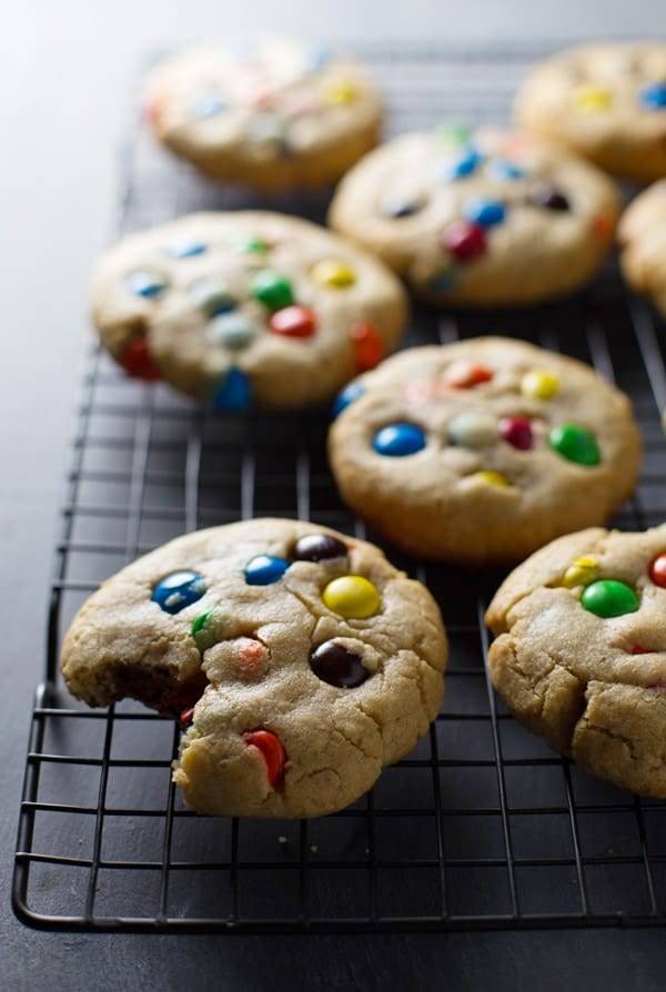 Big soft M&M cookies on a drying rack.