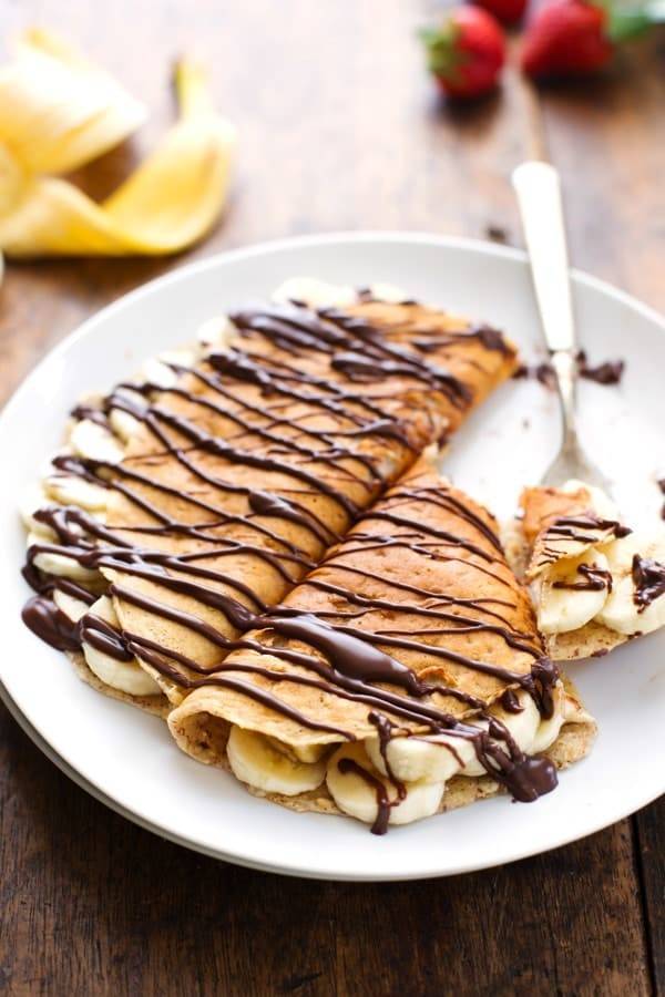 Almond Oat Banana Crepes with chocolate drizzle on a white plate.