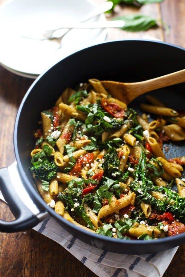 Lemon Pesto Penne in a skillet with a wooden spoon.