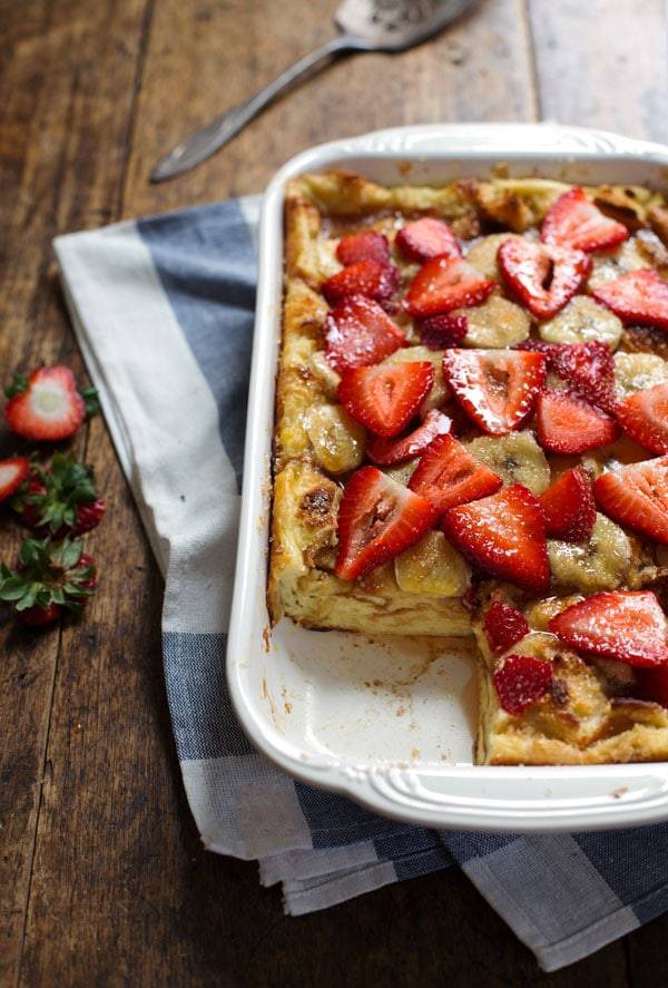 Coconut French Toast Bake with strawberries in a white dish.