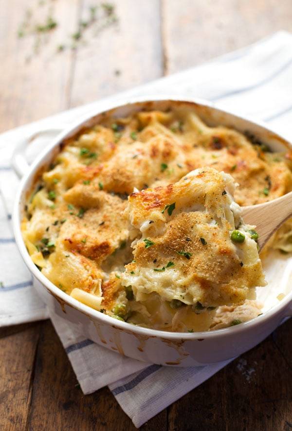 Garlic Parmesan Chicken Lasagna Bake in a white dish with a wooden spoon.