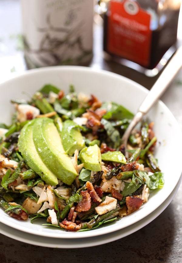Chicken Bacon Avocado Salad with Roasted Asparagus in a white bowl.
