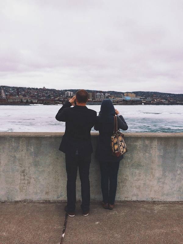 Man and woman taking photos of a lake.
