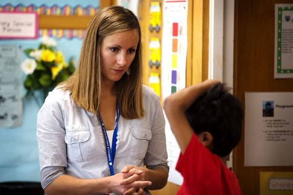 A teacher speaking with a kid.