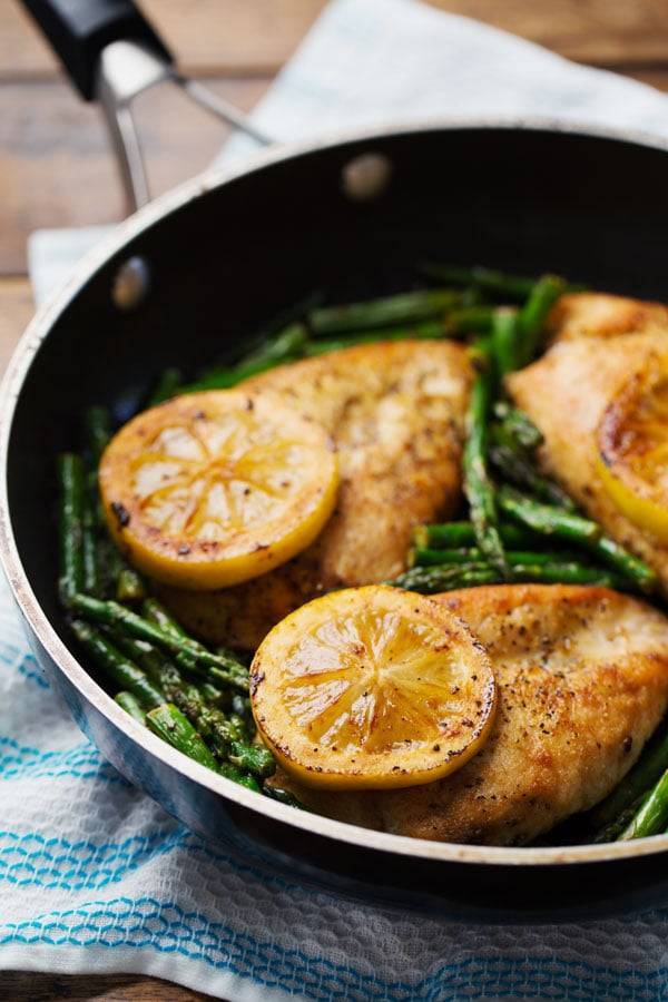 5 Ingredient Lemon Chicken and Asparagus in a black pan.