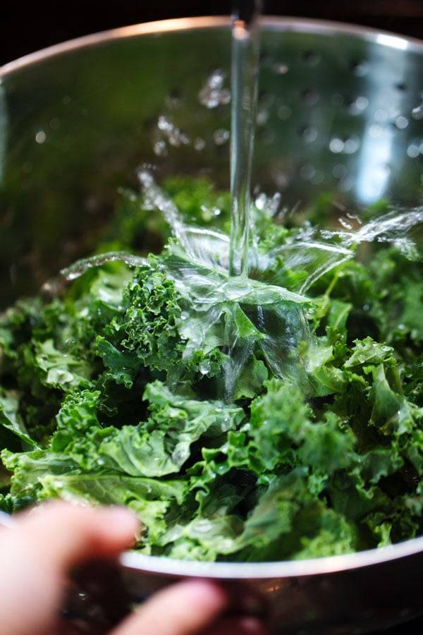 Washing kale under water.