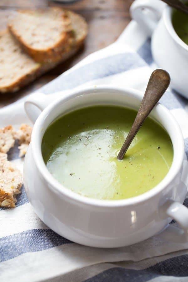 Creamy Potato Kale Soup in a white bowl with a spoon.