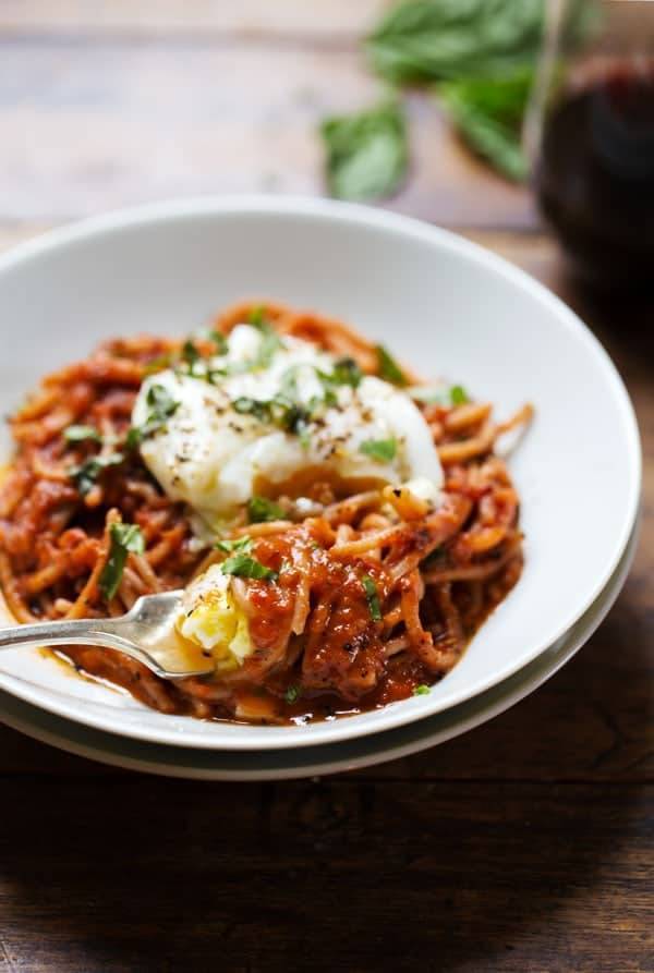 Spaghetti Marinara with Poached Eggs on a white plate.
