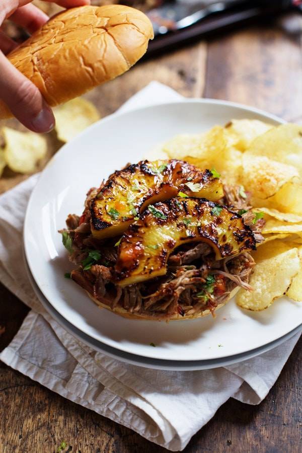 Grilled Pineapple Pork Sandwich on a plate with chips.