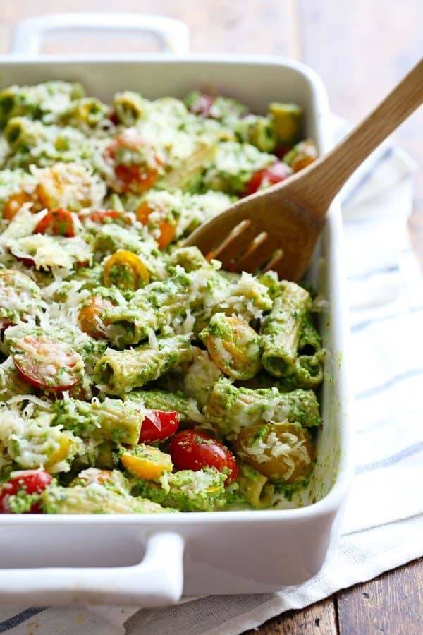 Baked Pesto Rigatoni in a baking dish with a wooden spoon.