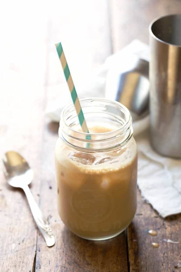Milk and Honey Iced Coffee in a jar with a striped straw.