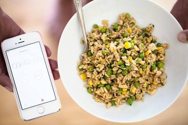 Veggie Fried Rice on a white plate with an iphone.