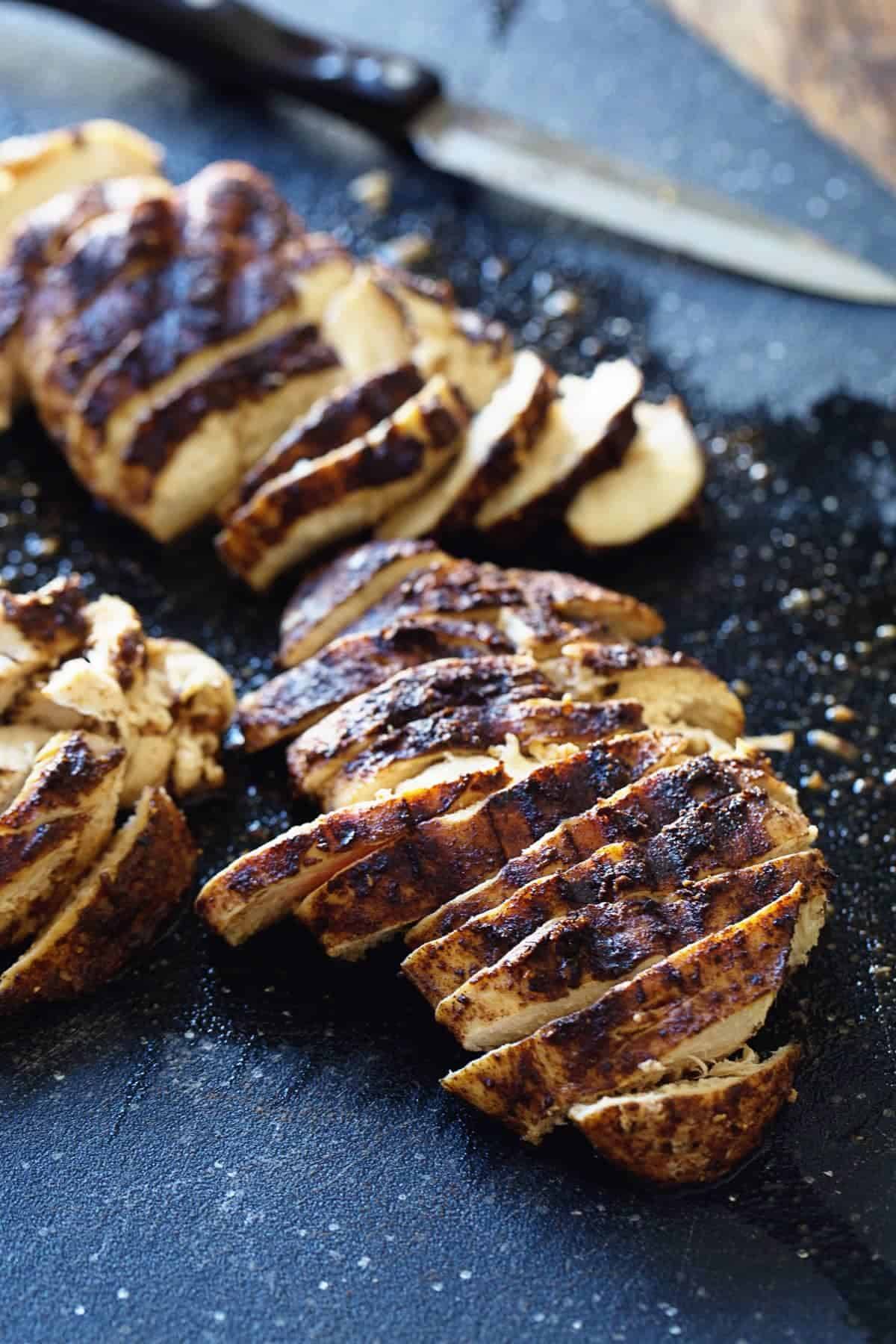 Jerk Chicken cut into pieces on a cutting board.