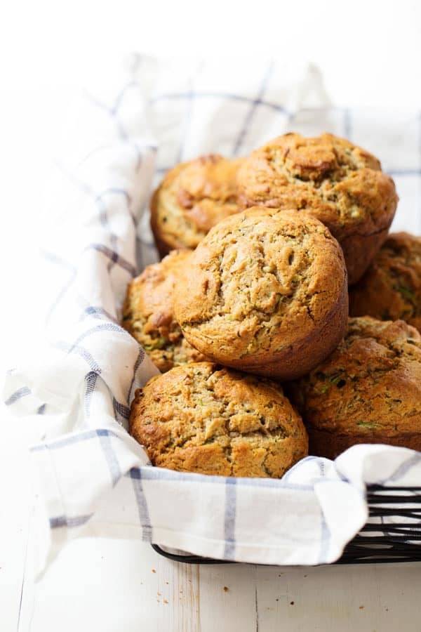 Honey and Olive Oil Zucchini Muffins stacked in a basket.