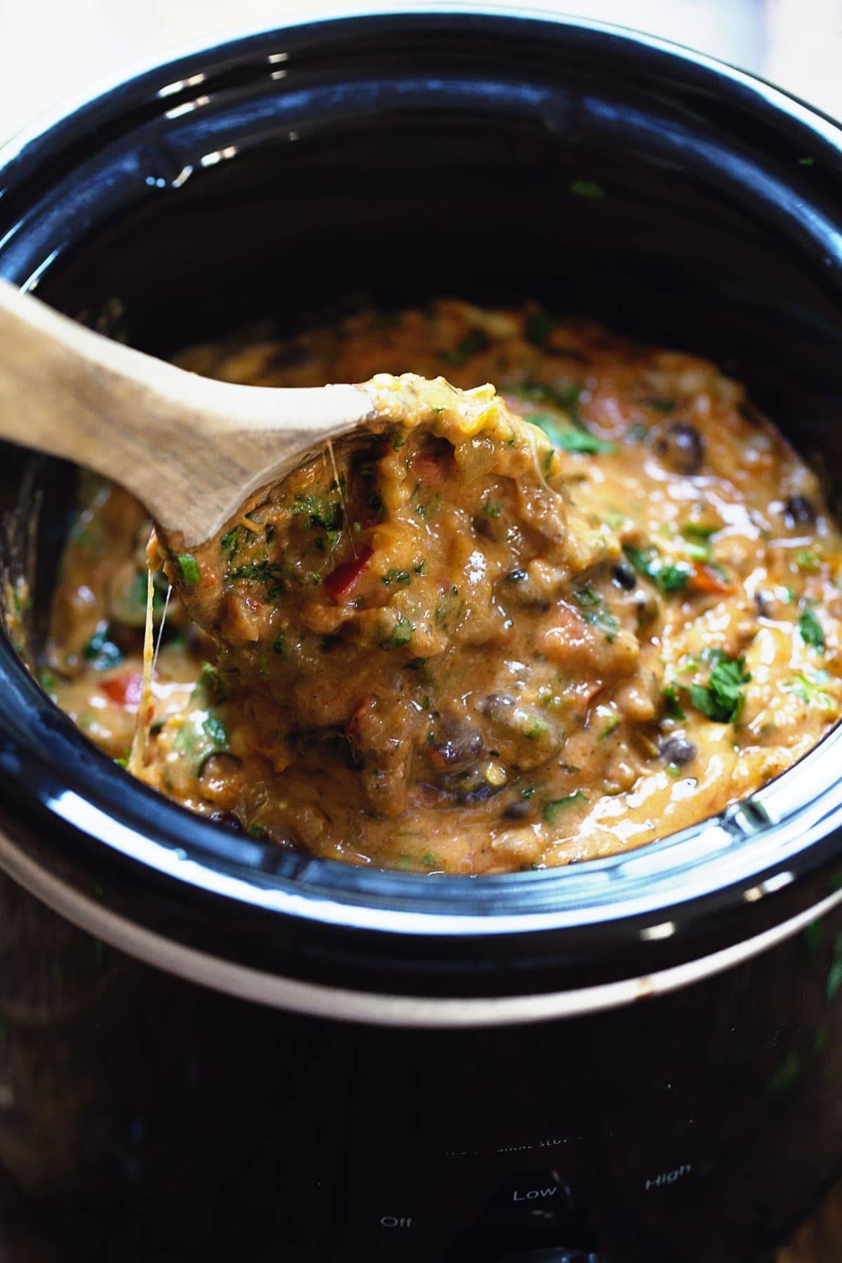 Cheesy Chili Dip on a wooden spoon.