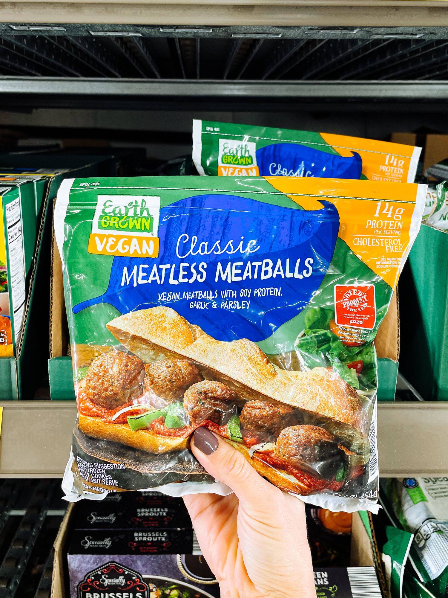 White hand holding meatless meatballs bag from ALDI.