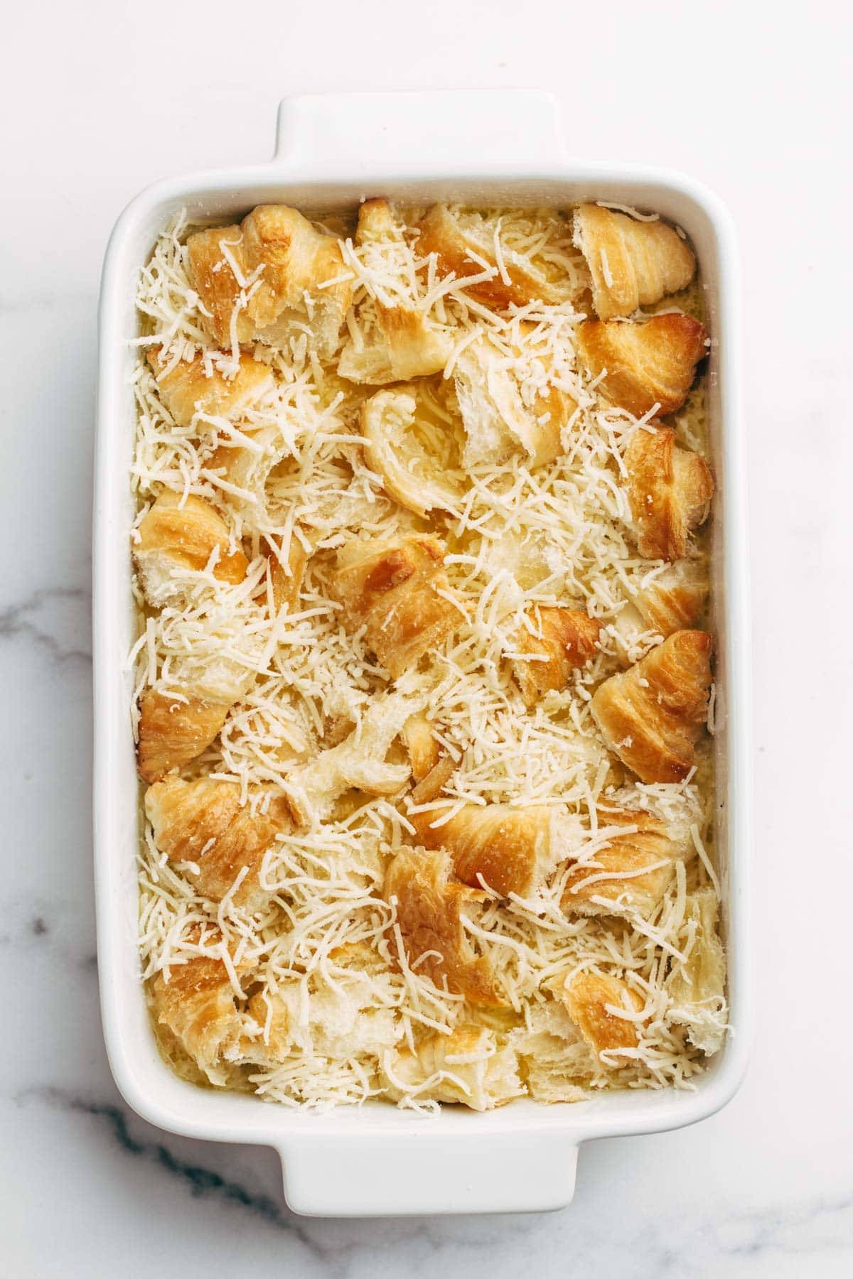 Cheese and croissant layered on a brunch bake.