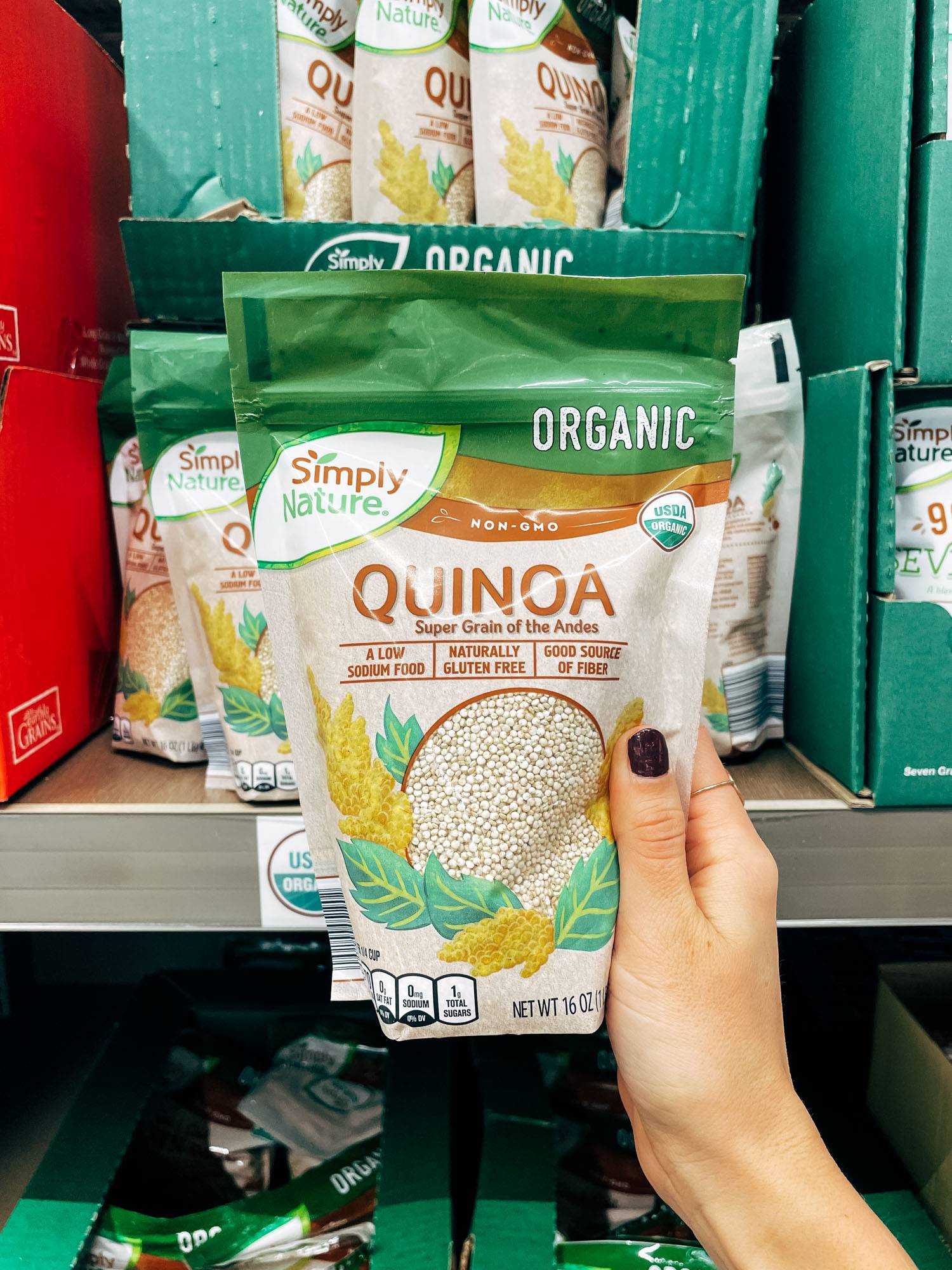 White hand holding a bag of quinoa