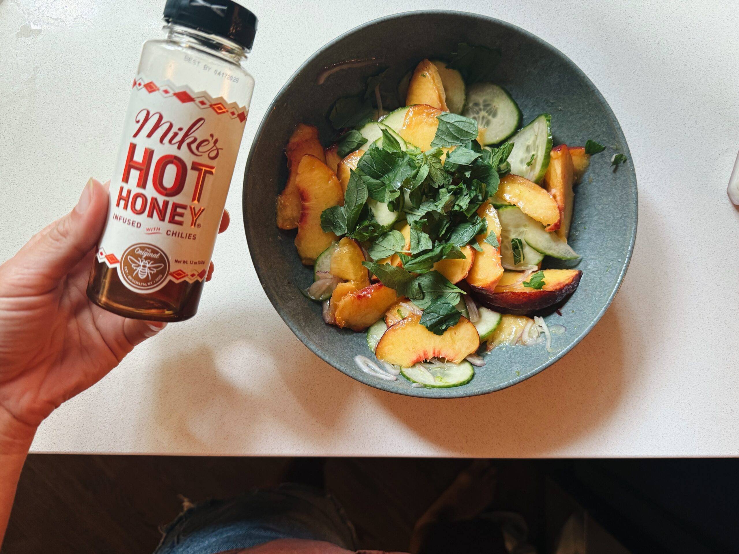Drizzling hot honey on top of a peach salad.