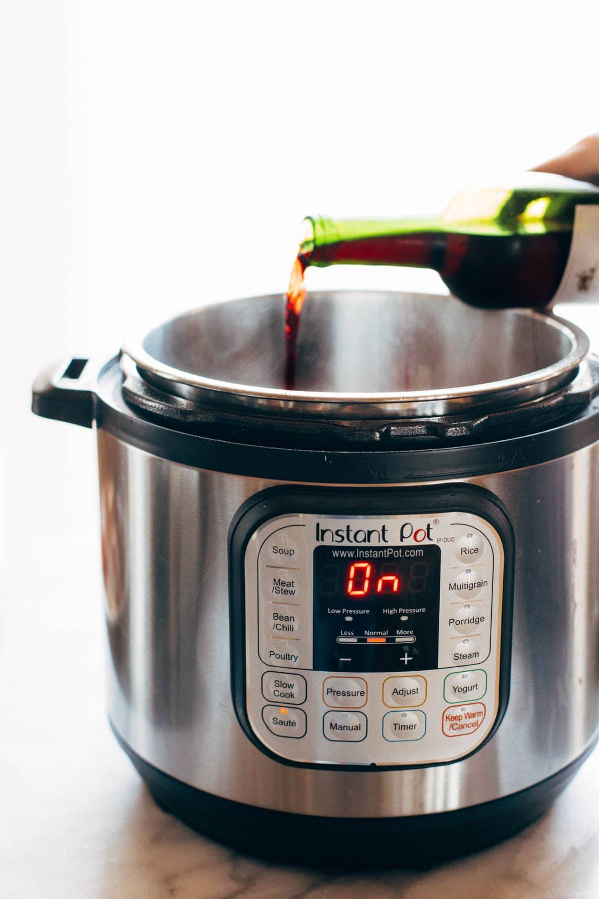 Pouring red wine into an Instant Pot.