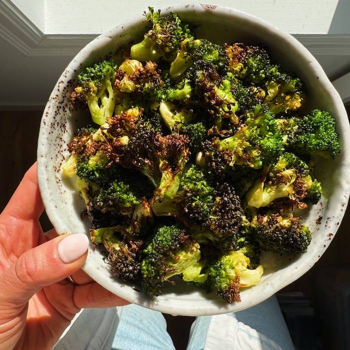 Air Fryer Broccoli in a bowl by the window.