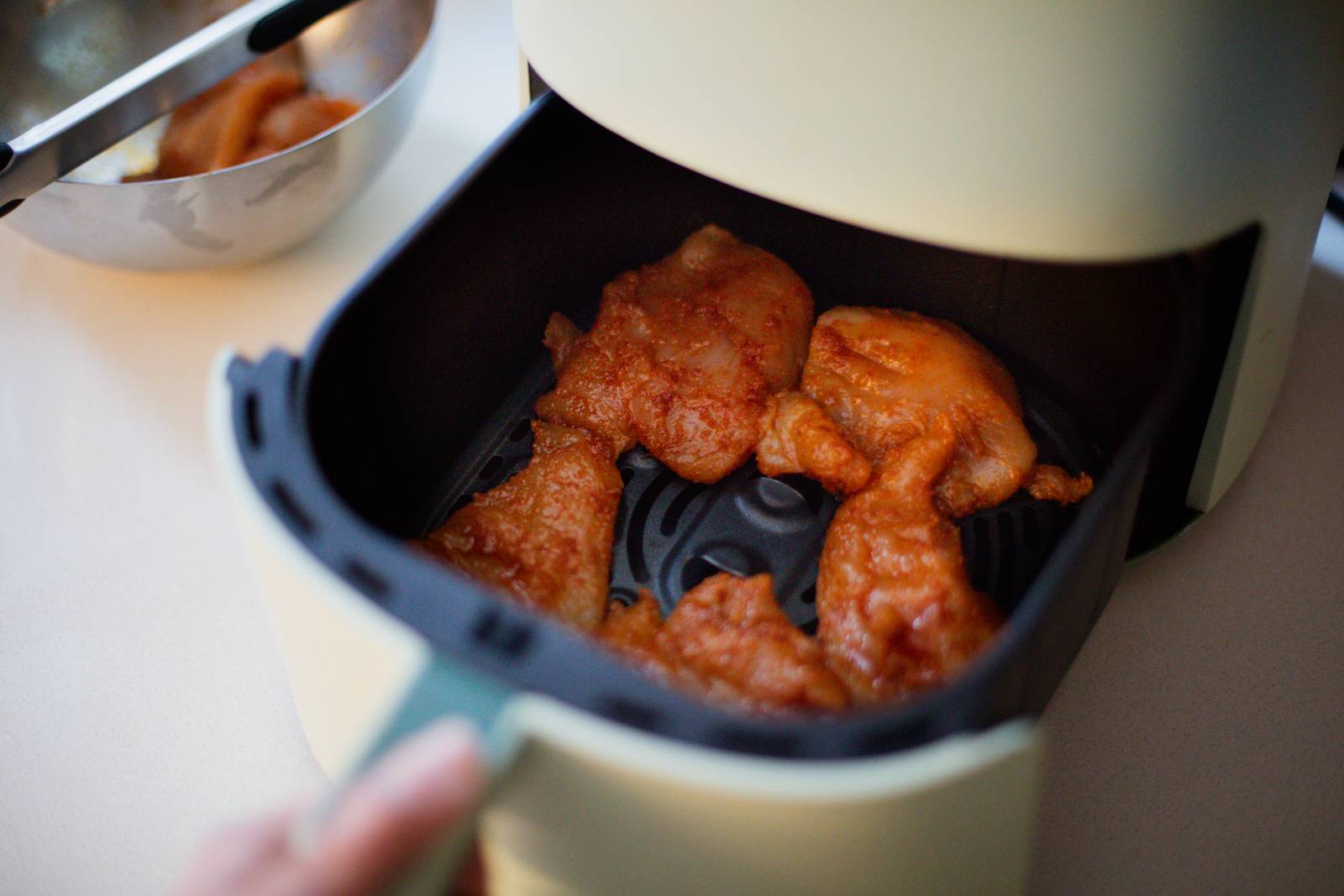 Chicken in air fryer basket before cooking.