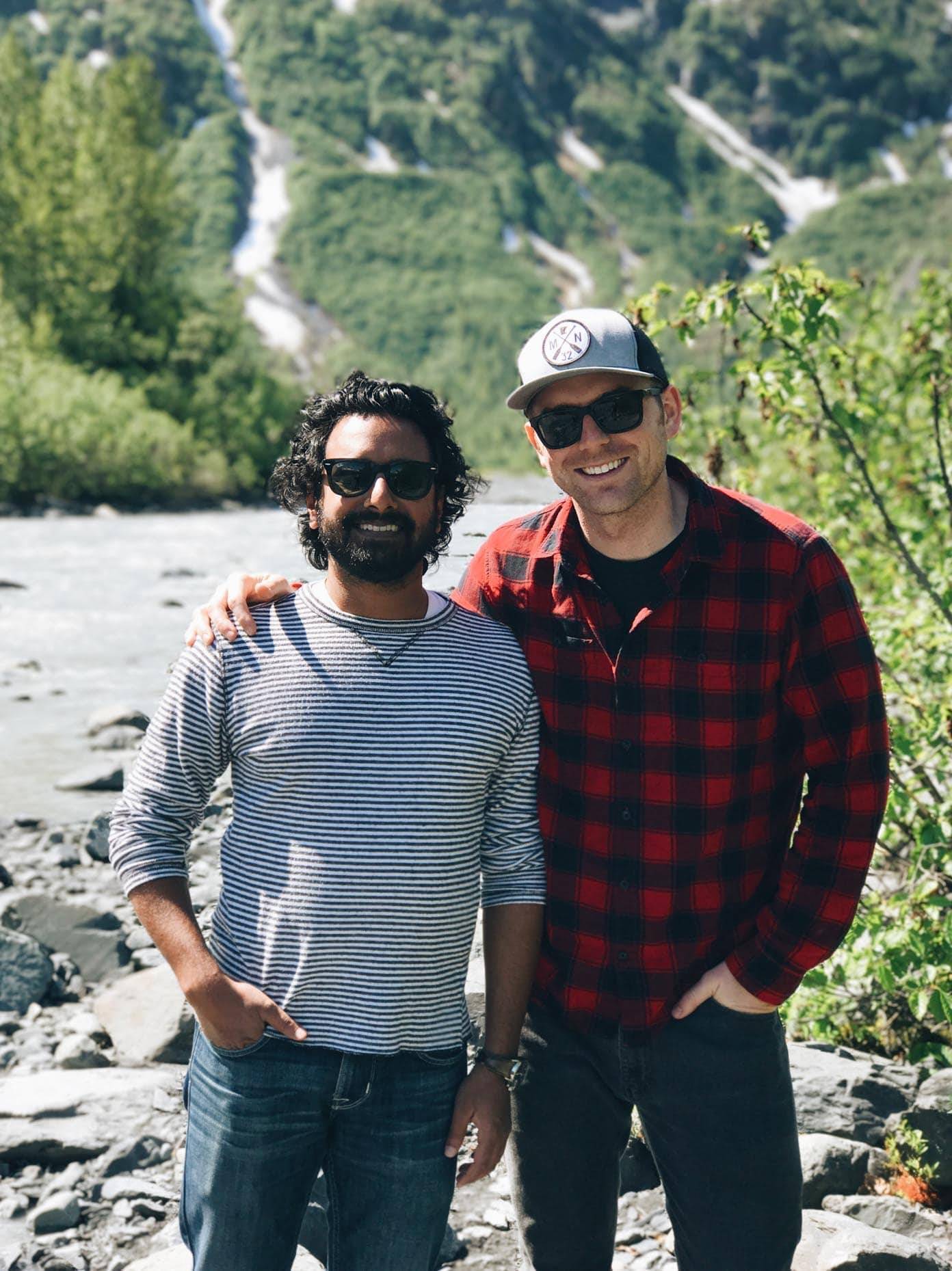 Two men wearing sunglasses on a rocky path.