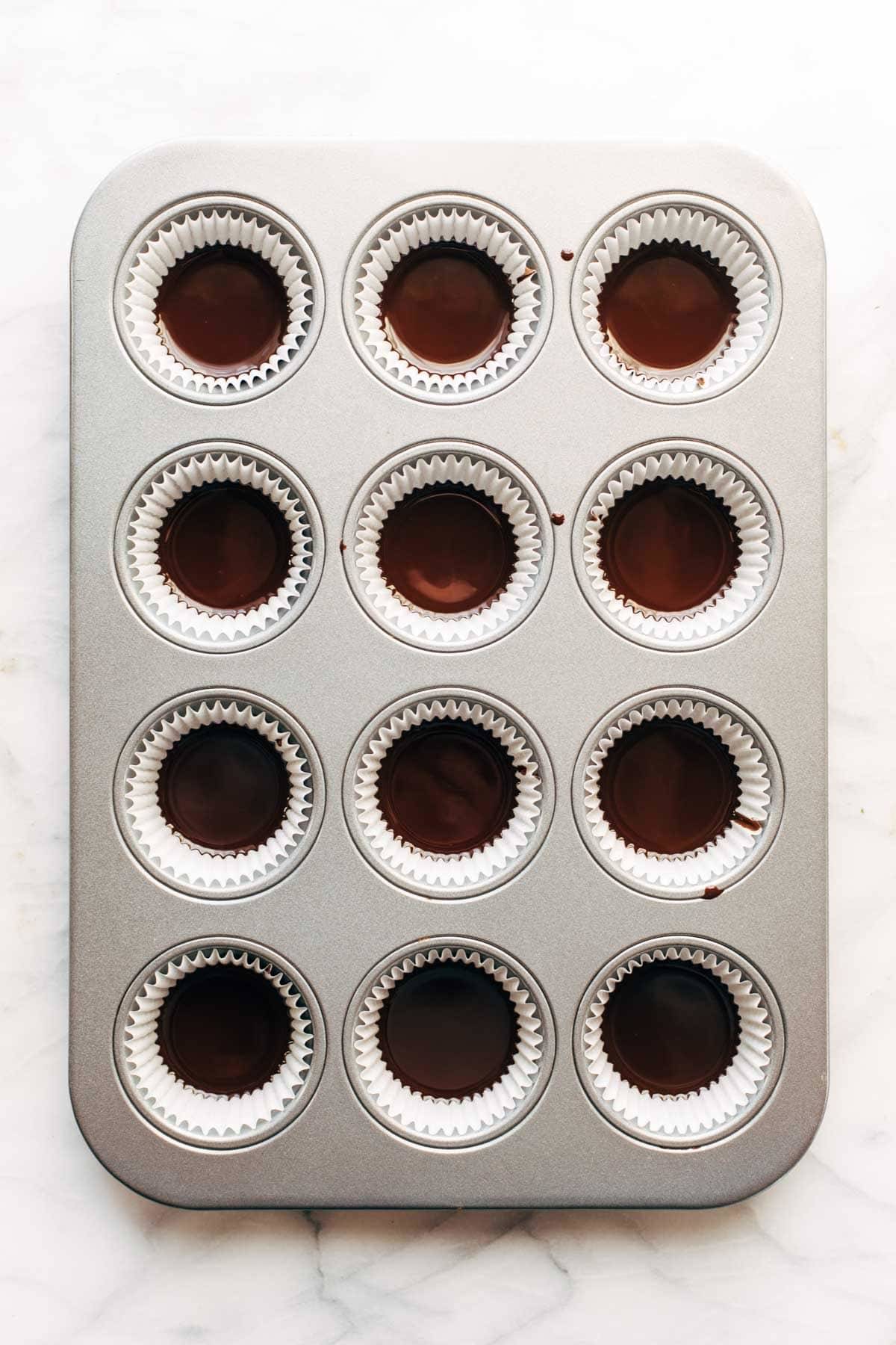 Almond butter cups chocolate in muffin pan.