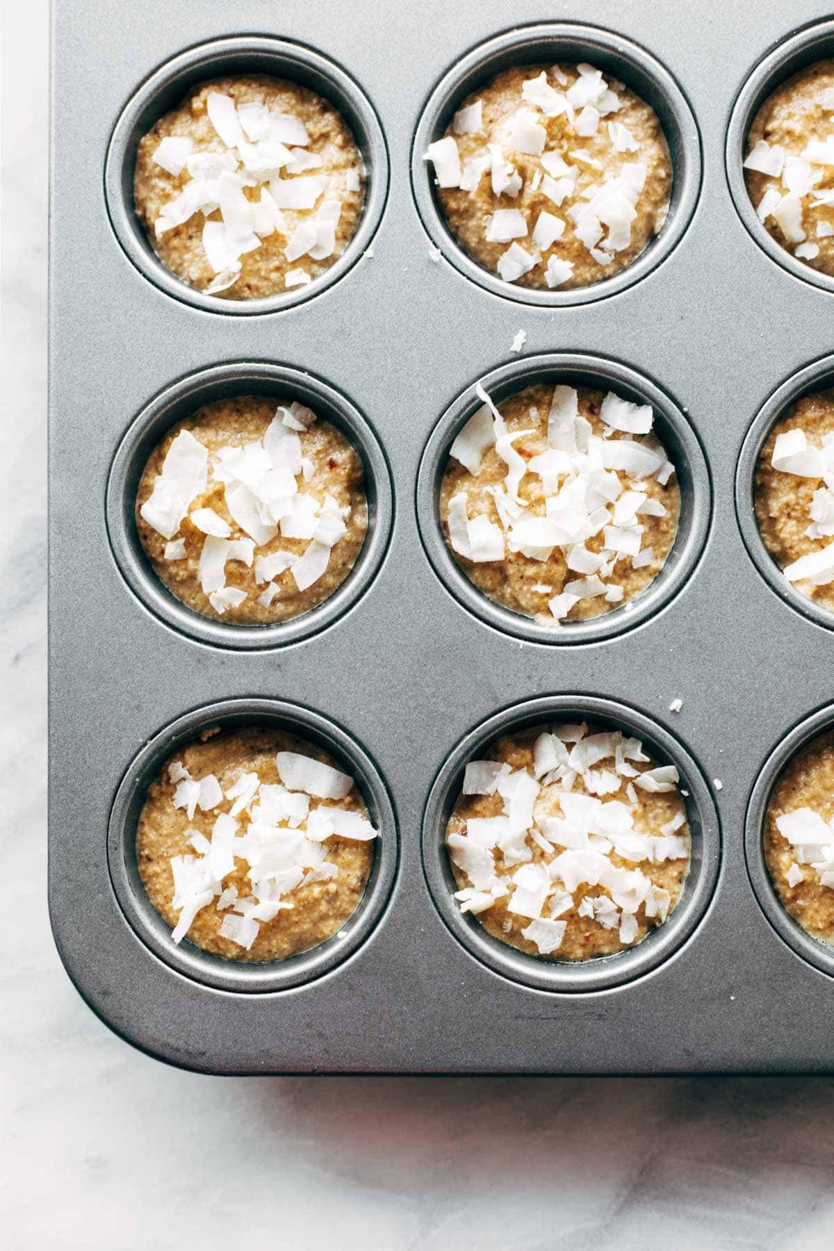 Apple muffins in a muffin tin before baking.