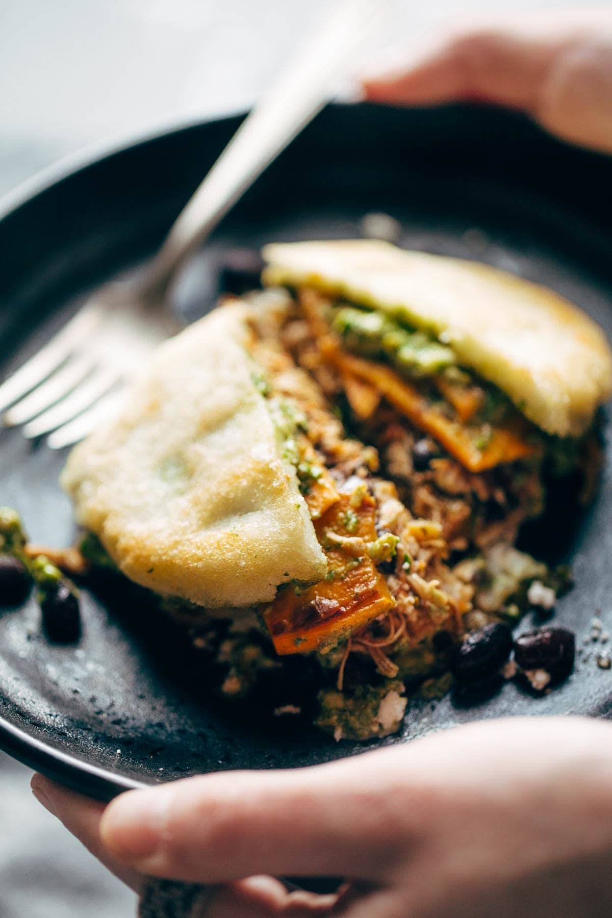 Arepa on a plate with a fork.