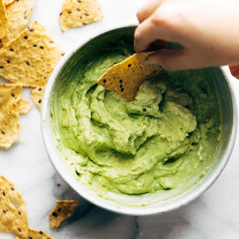 Avocado Dip in a bowl with chip.