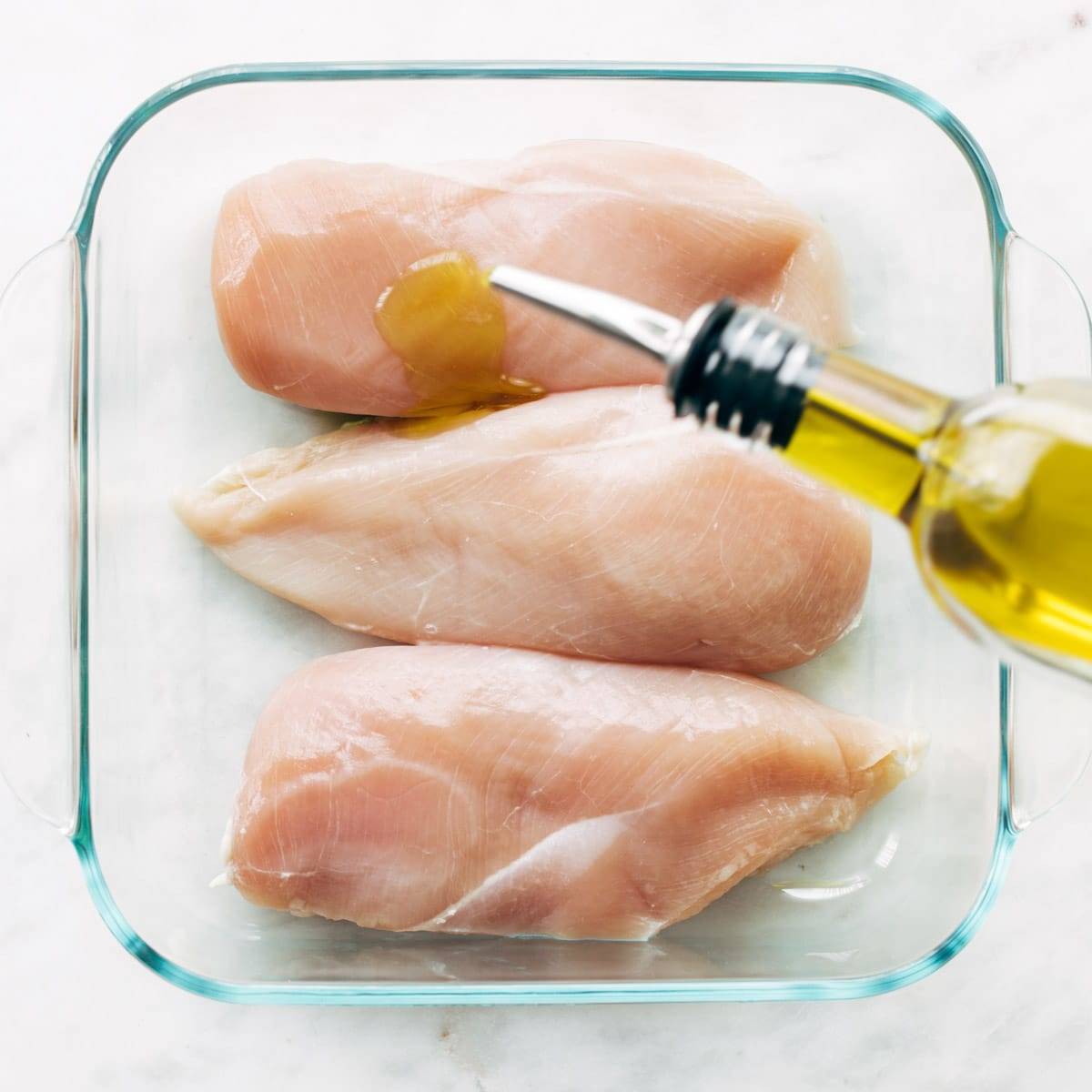 Raw chicken breasts in a baking dish.