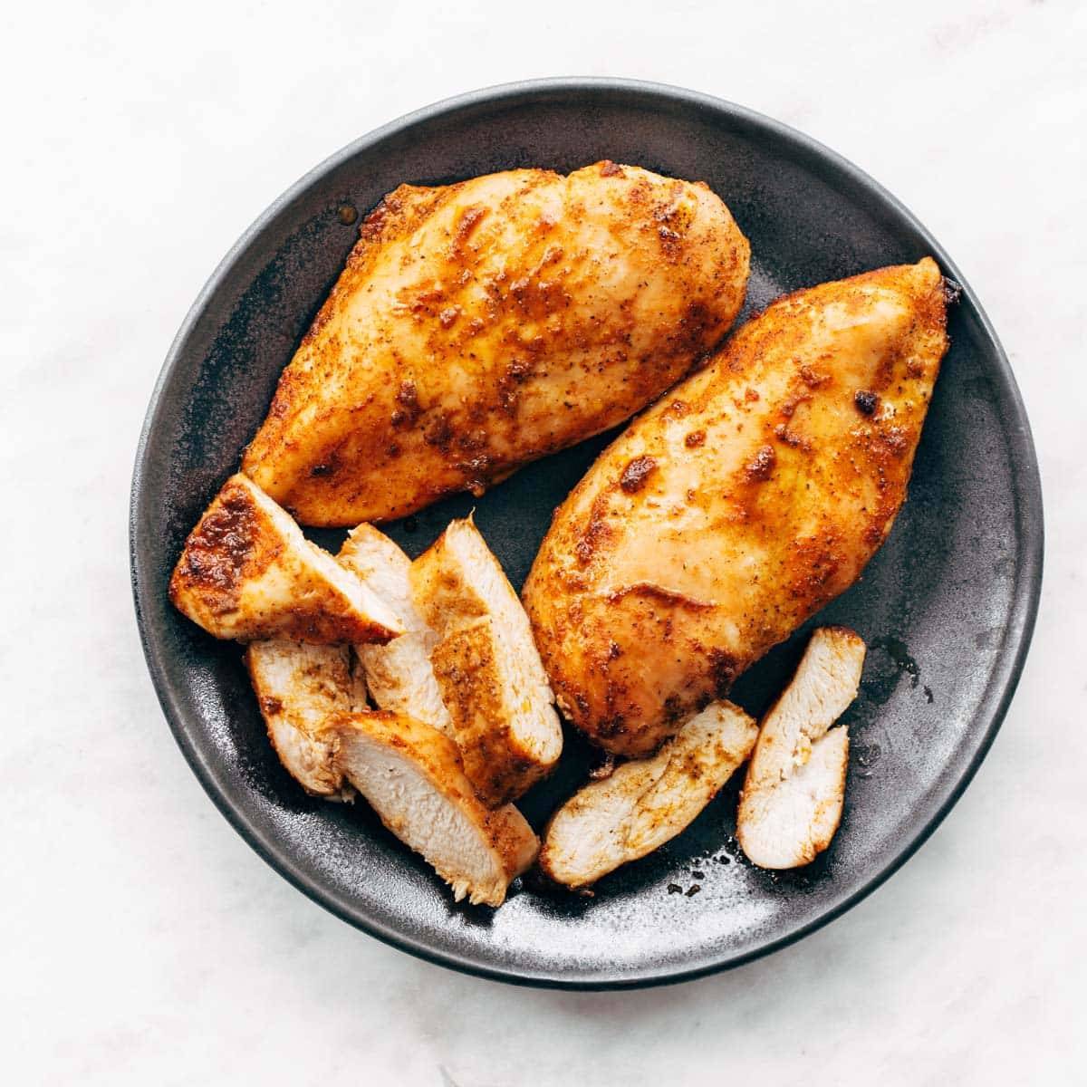 Cooked chicken breasts on a plate.