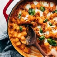 A bowl full of Baked Gnocchi with Vodka Sauce and a wooden spoon.