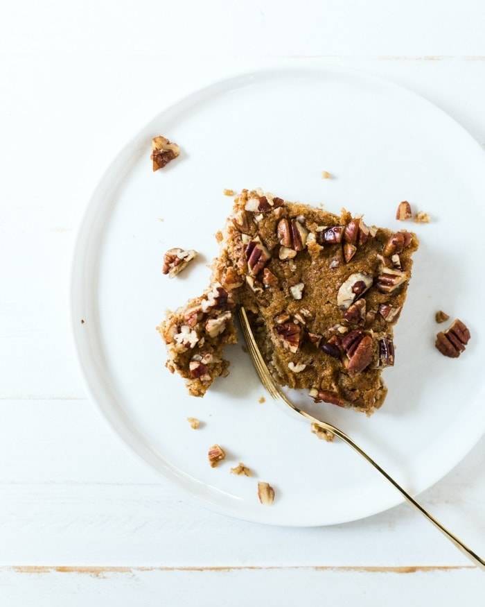 Baked oatmeal dessert with nuts on a plate with a fork.