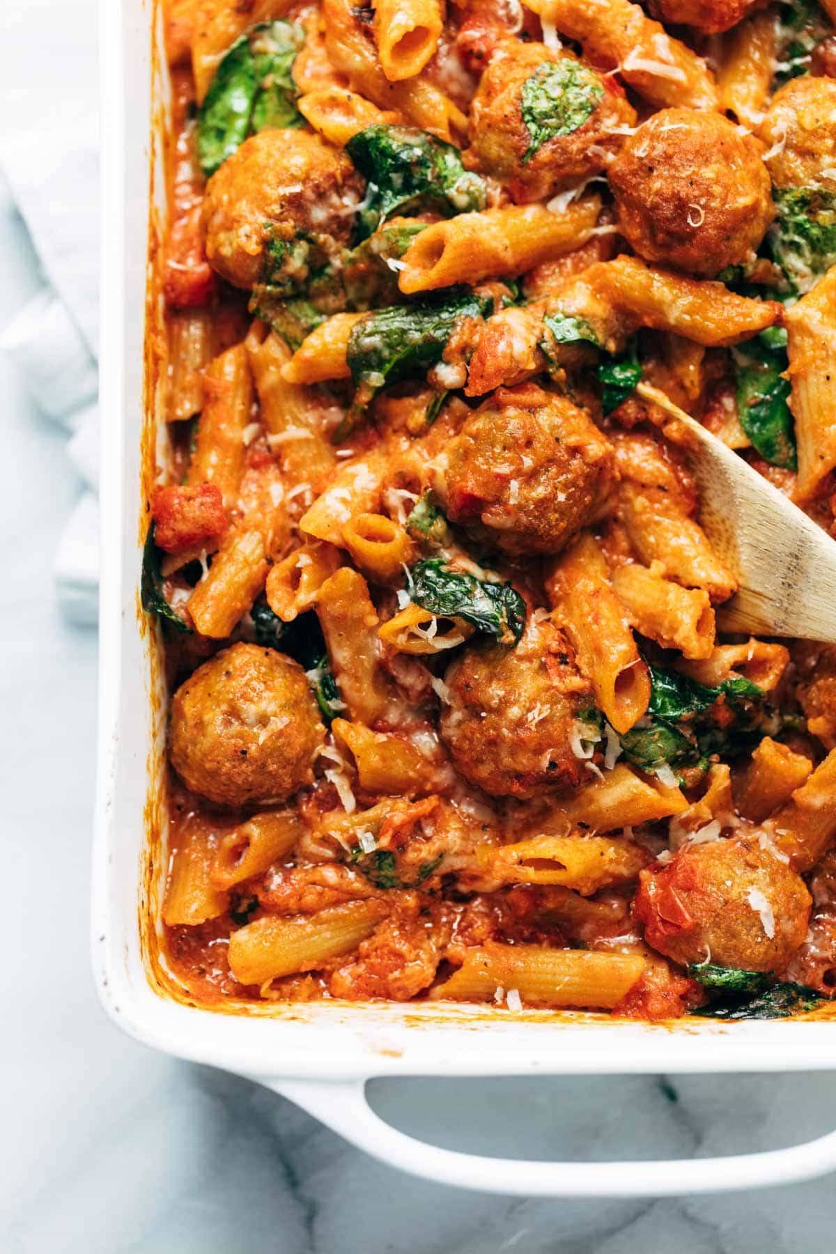 Baked penne with meatballs in a dish.