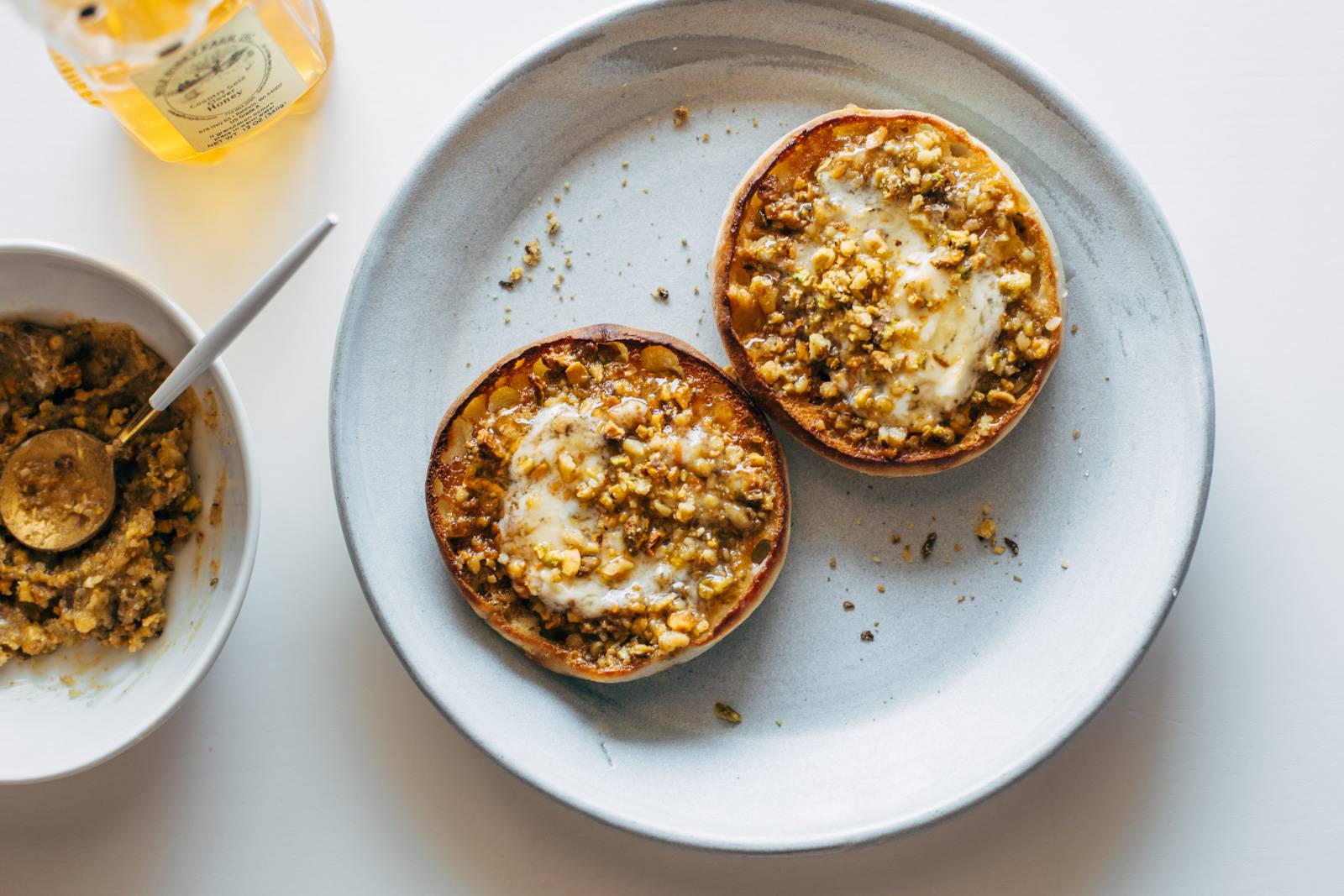 Mascarpone cheese gets spread with nuts and sugar on English muffins