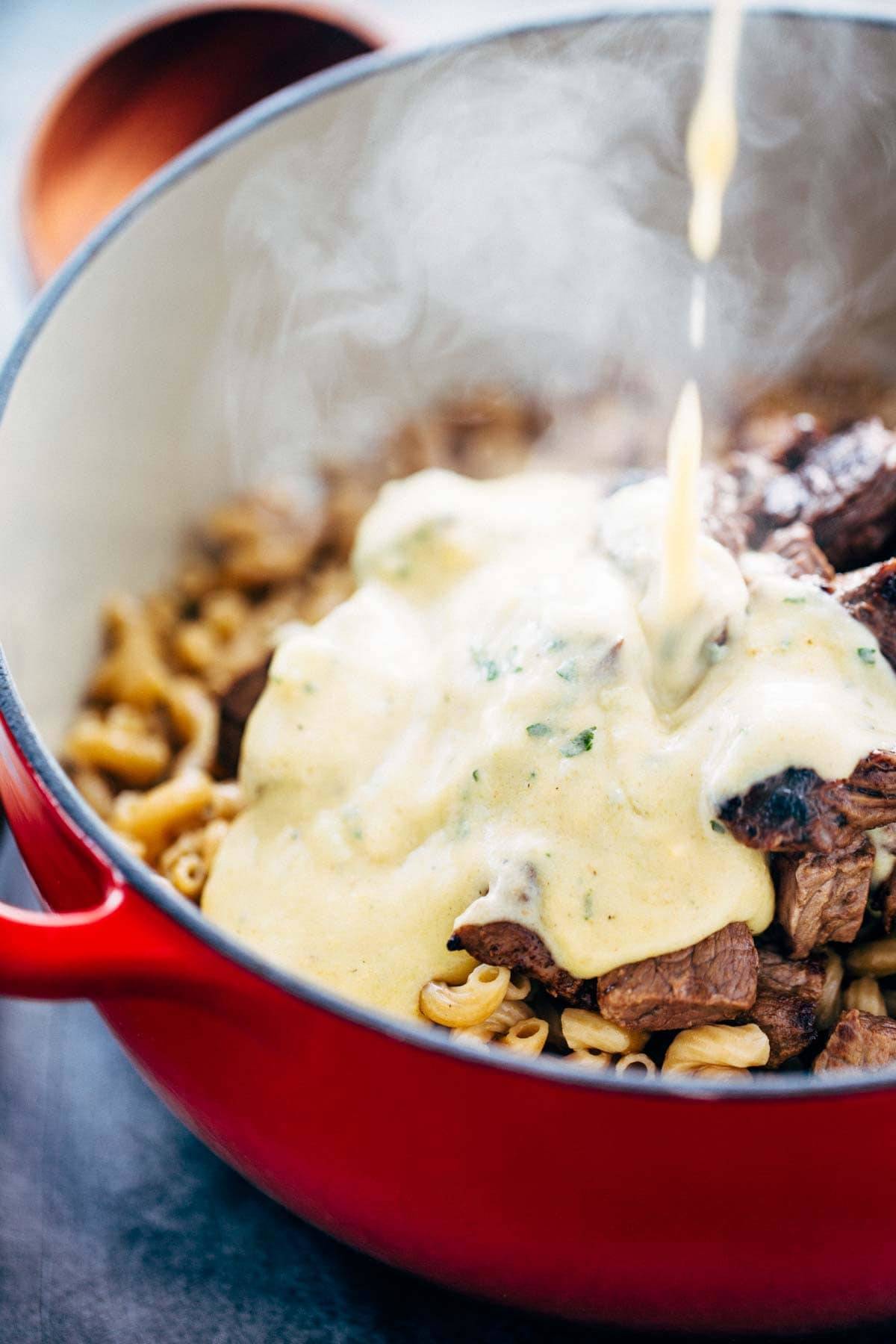 Creamy sauce on steak and noodles.