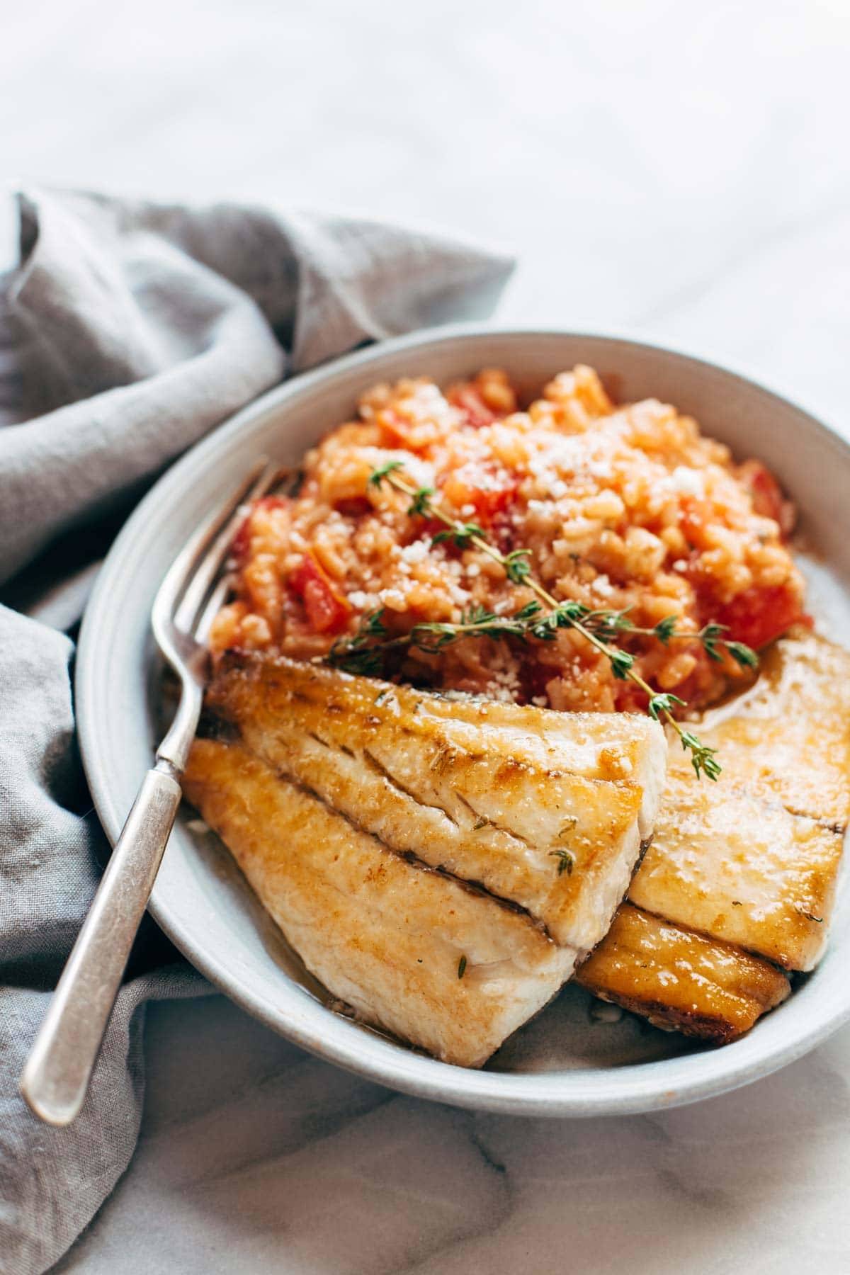 Creamy Tomato Risotto with Pan Fried Barramundi on a plate with a fork