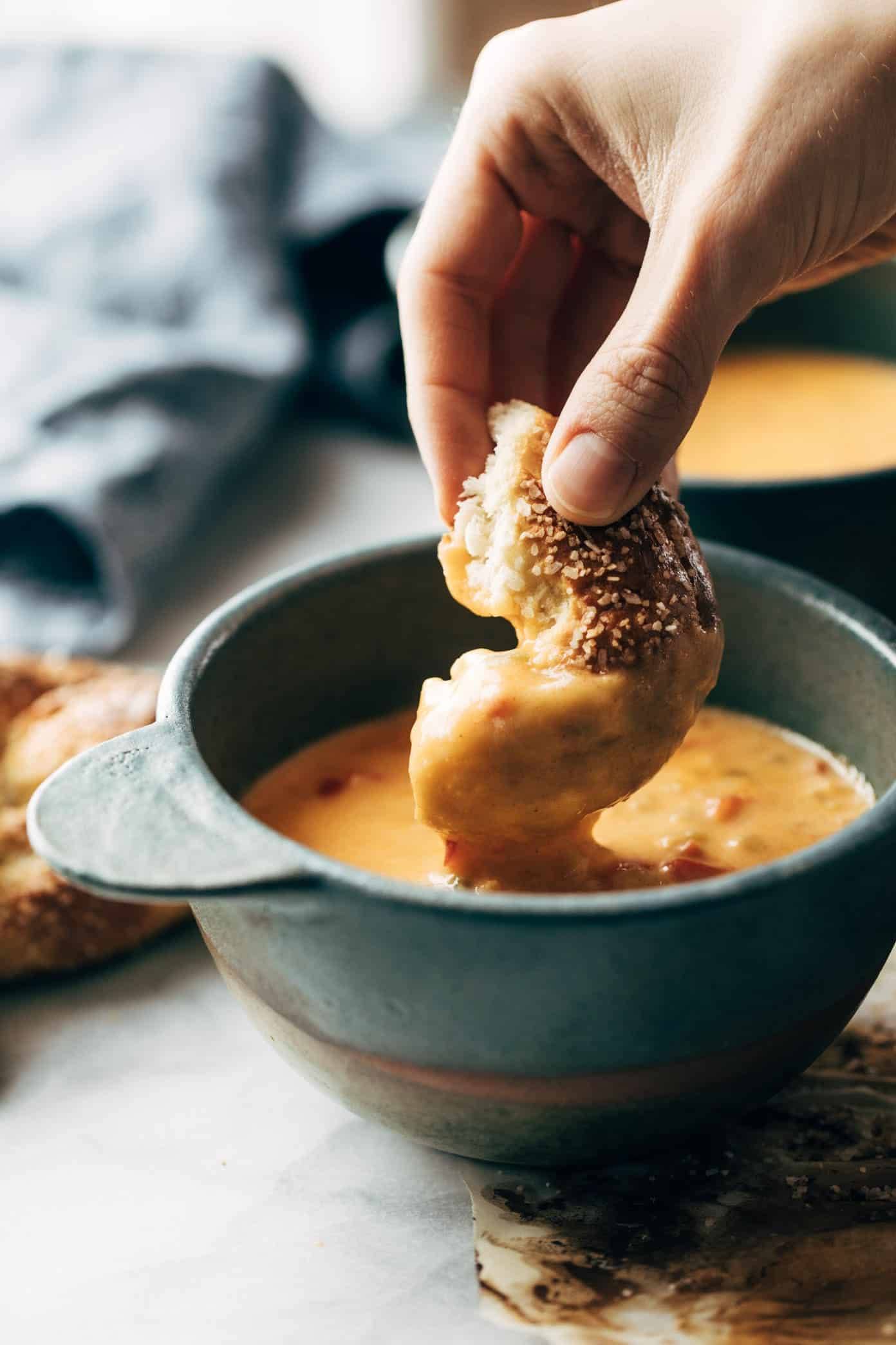 Pretzel bring dunked in Beer Cheese Soup.