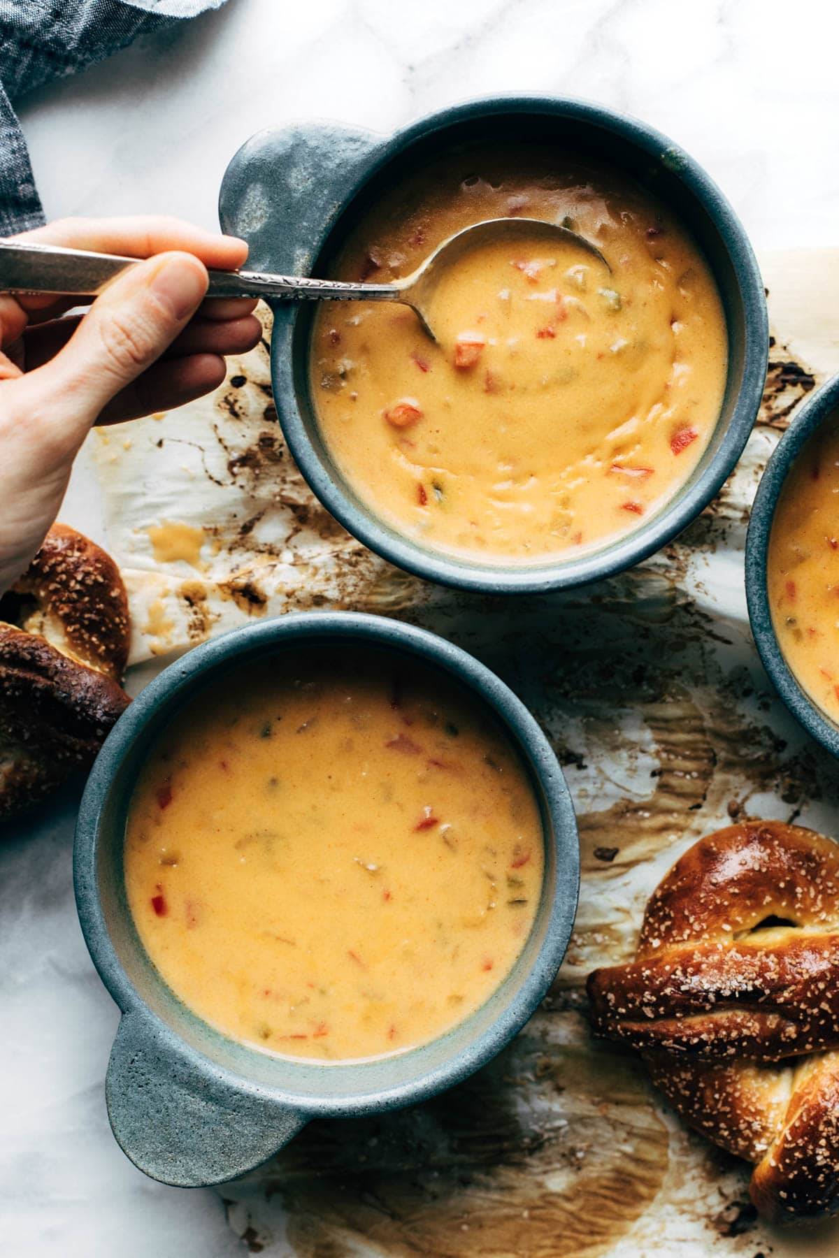 Bowls of Beer Cheese Soup with spoonful.